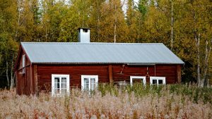 white and brown wooden house near green trees during daytime